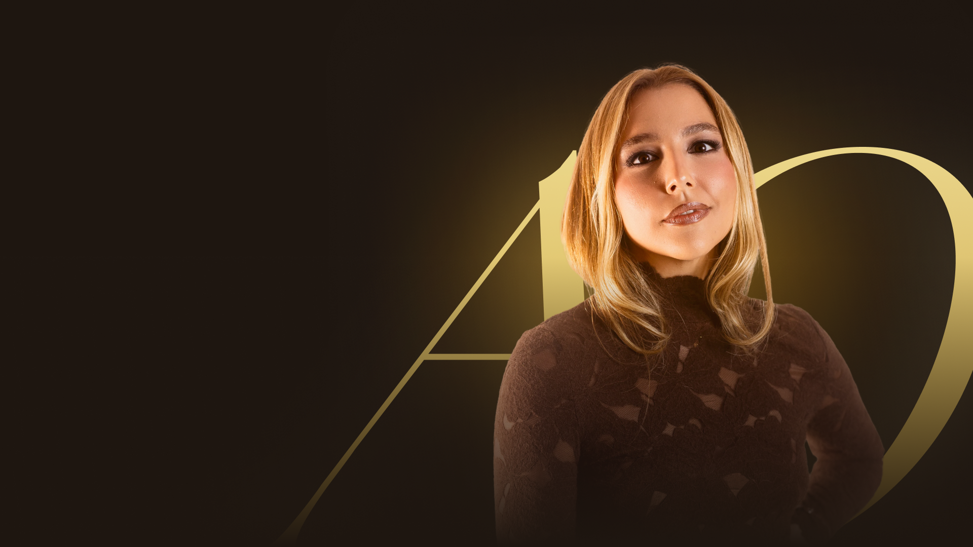 Ana Branco diante do monograma dourado da Imersão Além do Óbvio.